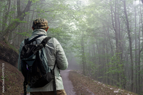 hiker in the woods trail with mist