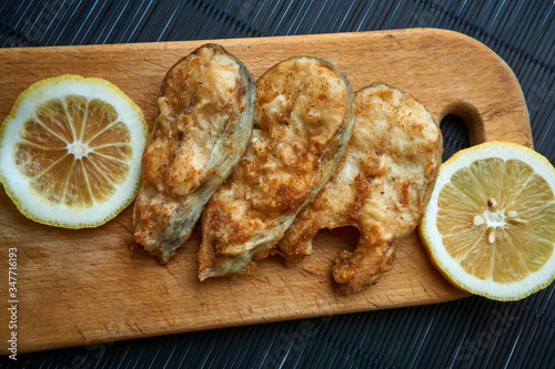 Pieces of fried fish with lemon wedges. photo