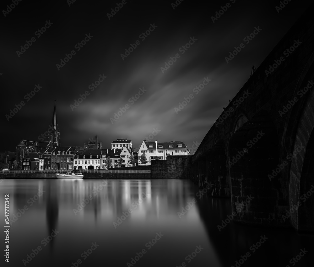 Maastricht, Limburg. Long exposure of the skyline of Maastricht, the Netherlands. With the medieval Sint Servaas bridge and the Sint Augustinus church. Black and white minimalism artistic image. 