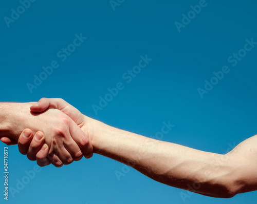 handshake between two men. Two hands. Love couple. Man and woman hands. Sky background. 