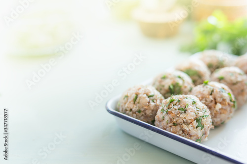 Delicious vegan buckwheat balls on kitchen table with ingredients. Healthy home cooking and eating. Сlose up, blurred background, place for text.