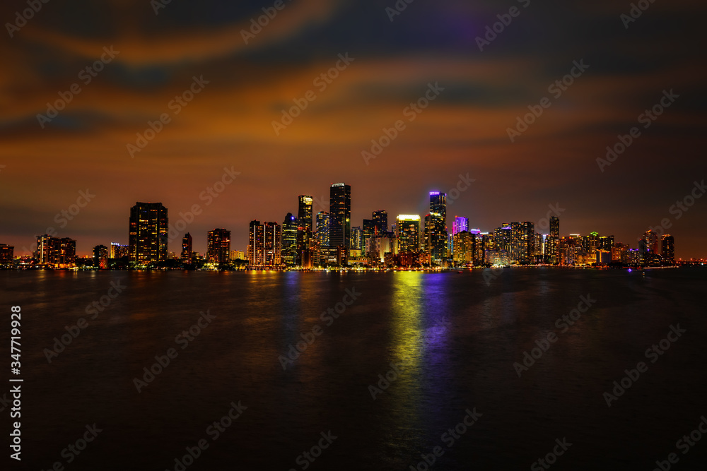 Miami downtown view at night. Miami city, Florida skyline panorama at dusk with urban skyscrapers and bridge over sea with reflection. Miami Florida, skyline.
