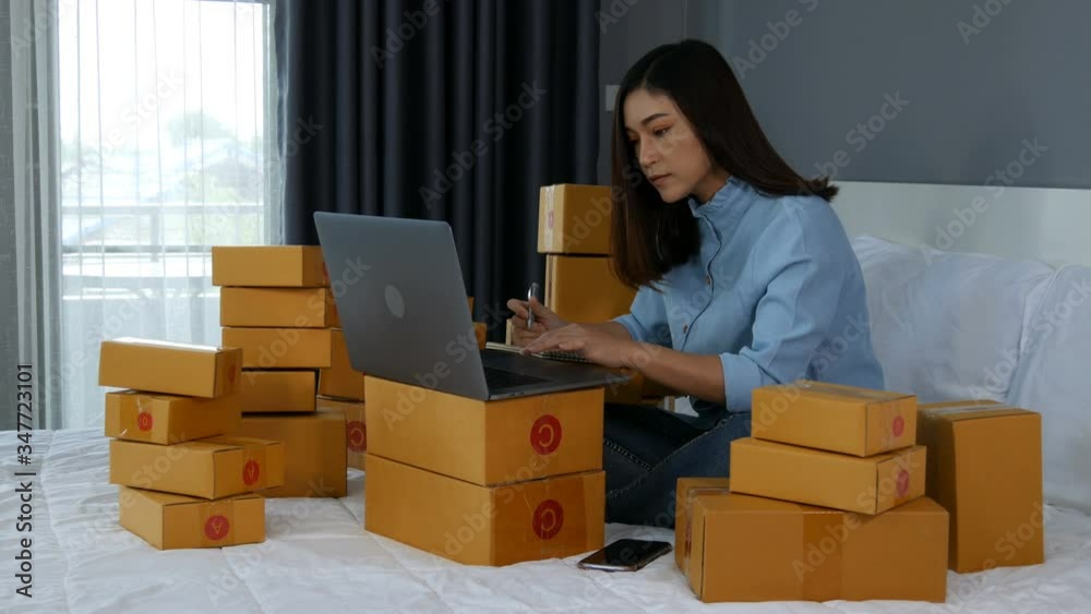 young woman working and using laptop computer to selling product online on a bed at home young woman working and using laptop computer to selling product online on a bed at home