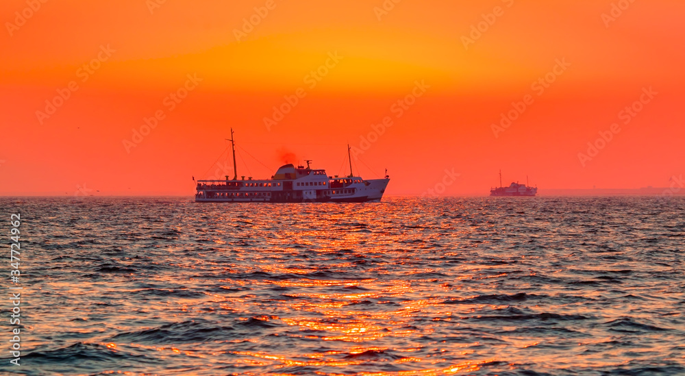Water trail foaming behind a passenger ferry boat in the Gulf of Izmir at sunset - Izmir, Turkey