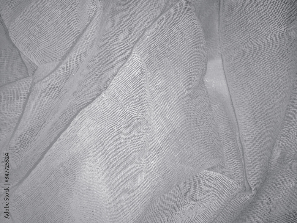 White mesh texture close-up. Cotton fabric with weaving, blank background  of medical gauze with folds