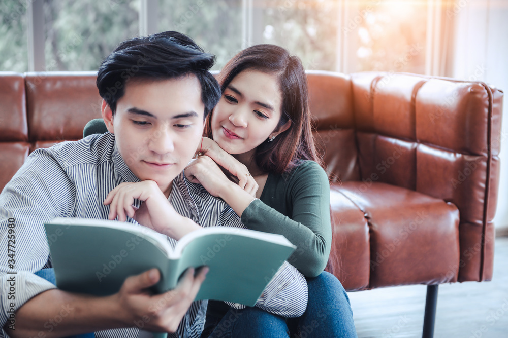 Portrait of Young Couple Love in Romantic Emotions While Reading a Book Together, Couple Young People Having Fun and Relaxing in Living Room. Happy Emotion and Relaxation Lifestyles Concept