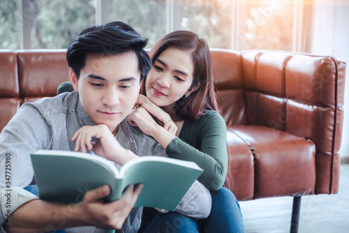 Portrait of Young Couple Love in Romantic Emotions While Reading a Book Together, Couple Young People Having Fun and Relaxing in Living Room. Happy Emotion and Relaxation Lifestyles Concept