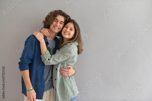 Young couple standing on grey background