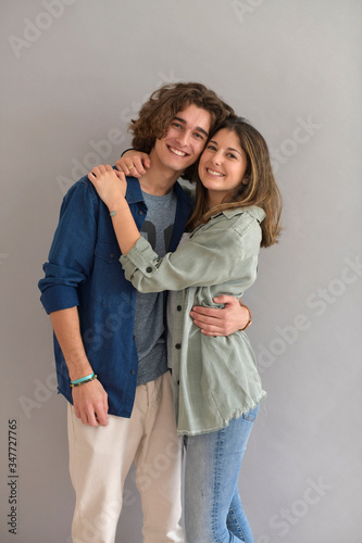 Young couple standing on grey background
