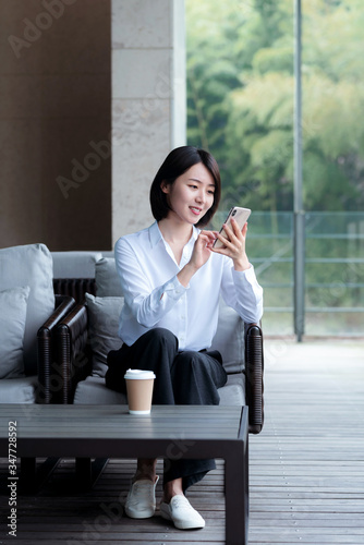 Asian business woman using mobile phone  in the outdoors