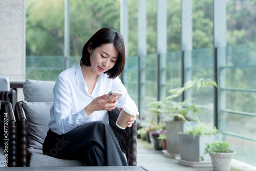 Asian business woman using mobile phone  in the outdoors