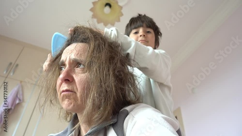 Fethiye, Turkey - 12h of May, 2020: 4K Lockdown meltdown Selfie - Old looking apathic mother being combed by her child
 photo