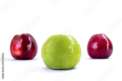 One green apple and two red apples on a white background. Organic fruit. Healthy lifestyle. Sweet fruit. Natural vegetarian healthy food. White background.