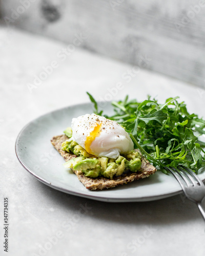 Tasty sandwich with poached egg and avocado on mrble background with copy space photo