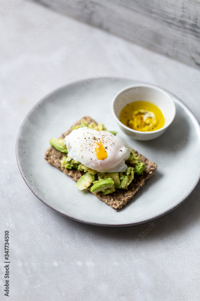 Tasty sandwich with poached egg and avocado on mrble background with copy space Tasty sandwich with poached egg and avocado on mrble background with copy space
