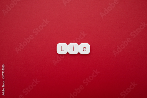 Alphabet lie word block with red background.
