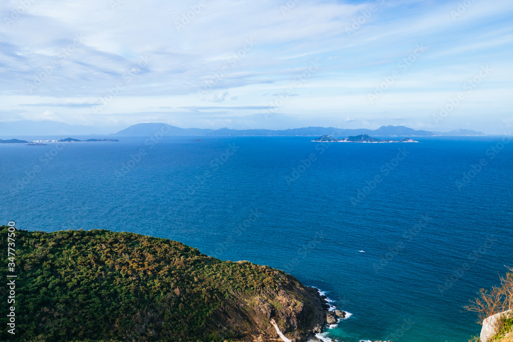 The blue sea, the hills covered with greenery in the background. Panoramic view of the sea landscape The blue sea, the hills covered with greenery in the background. Panoramic view of the sea landscape