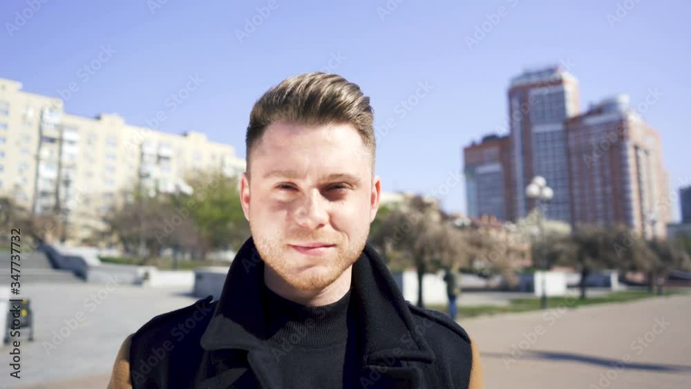 Stylish young serious caucasian man stand on street, looking at camera. Urban portrait Stylish young serious caucasian man stand on street, looking at camera. Urban portrait