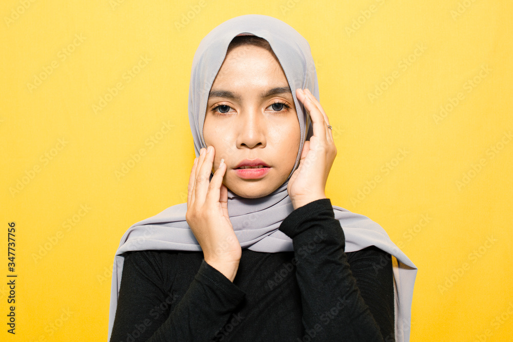 Asian woman smiling wearing hijab on yellow background Asian woman smiling wearing hijab on yellow background