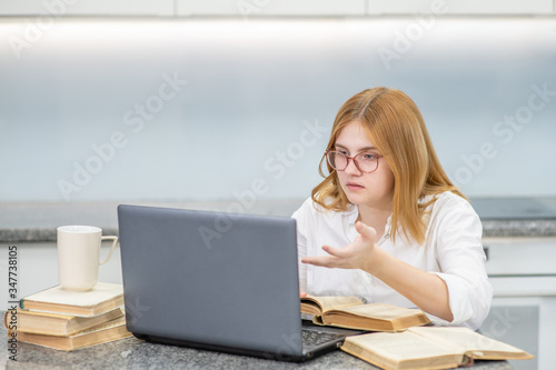 Teen girl talks with her teacher with laptop at home. Distance learning concept © Ermolaev Alexandr