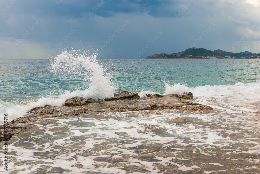 Wave splash on stones on the coast