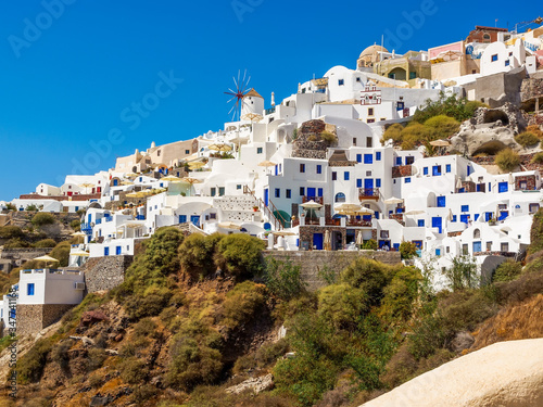 Amazing Santorini view on white cave houses from the Aegean sea. Cyclades, Greece