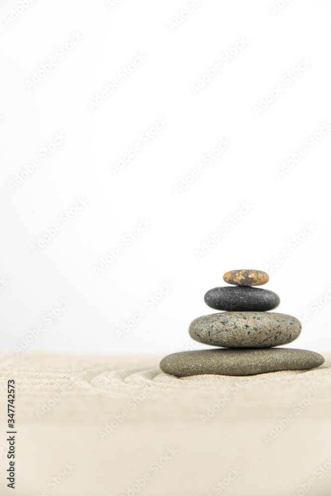 Zen garden. Pyramids of white and gray zen stones on the white sand with abstract wave drawings. Concept of harmony, balance and meditation, spa, massage, relax. Zen garden. Pyramids of white and gray zen stones on the white sand with abstract wave drawings. Concept of harmony, balance and meditation, spa, massage, relax.