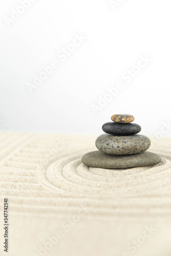 Zen garden. Pyramids of white and gray zen stones on the white sand with abstract wave drawings. Concept of harmony  balance and meditation  spa  massage  relax.