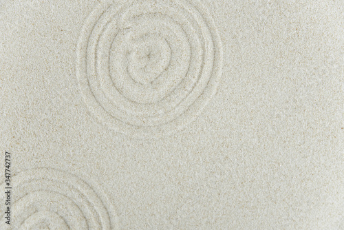 Abstract Zen drawing on white sand. Concept of harmony, balance and meditation, spa, massage, relax. Zen garden