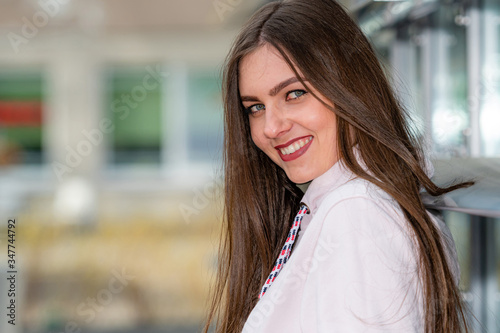 portrait of young emotional brunette woman on a defocused city background