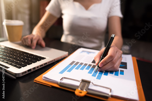 business documents on office table with smart phone and digital tablet and graph financial and man working 