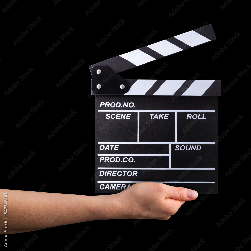 Human hand holding film clapper board isolated on black background