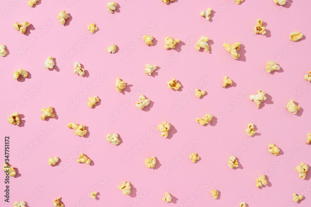 Food pattern from delicious popcorn on a light pink background. Food pattern from delicious popcorn on a light pink background.