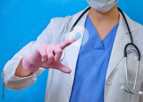 The doctor's hands in protective gloves press the virtual button, blue background. A nurse in a white lab coat with a finger pointing to the side, copy space