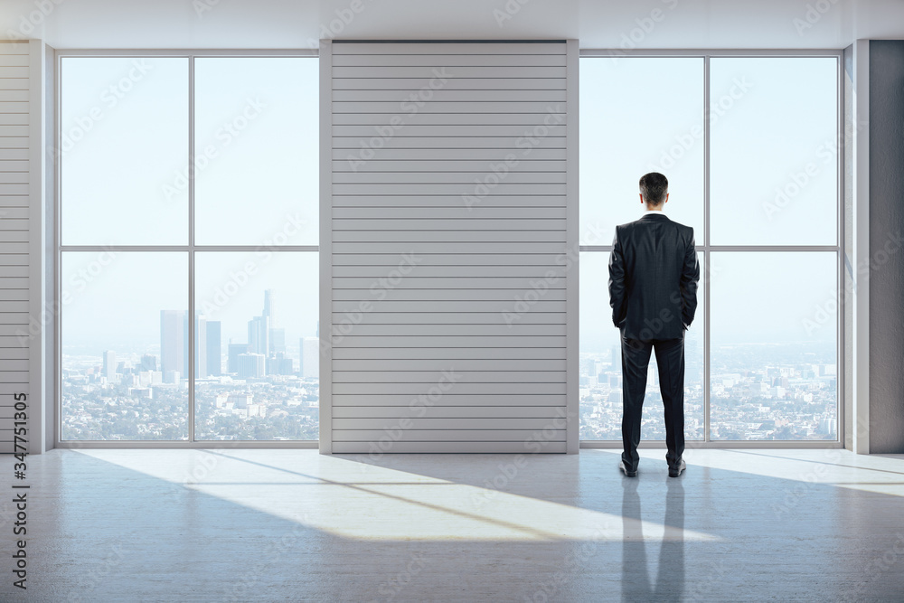 Businessman standing in exhibition interior and looking to city. Businessman standing in exhibition interior and looking to city.