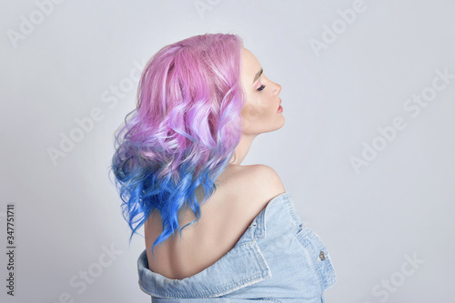 Portrait of a woman with bright colored flying hair  all shades of purple. Hair coloring  beautiful lips and makeup. Hair fluttering in the wind. Sexy girl with short  hair. Professional coloring