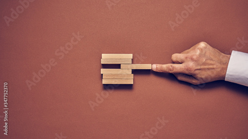 Męska dłoń i drewniane klocki ułożone w konceptualnym wizerunku