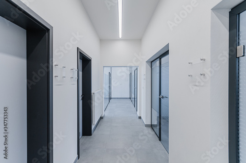 empty white walls corridor with doors in modern office building