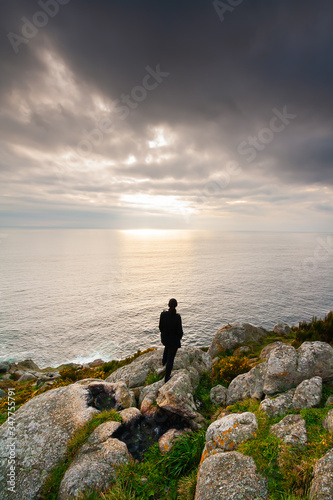 Woman observing the horizon on a cliff