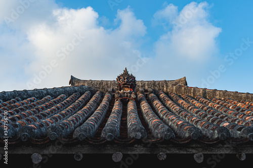 Shisa sitting on a traditional Okinawan house