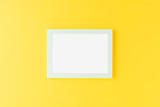 Blue picture frame on yellow background. Mockup with copyspace