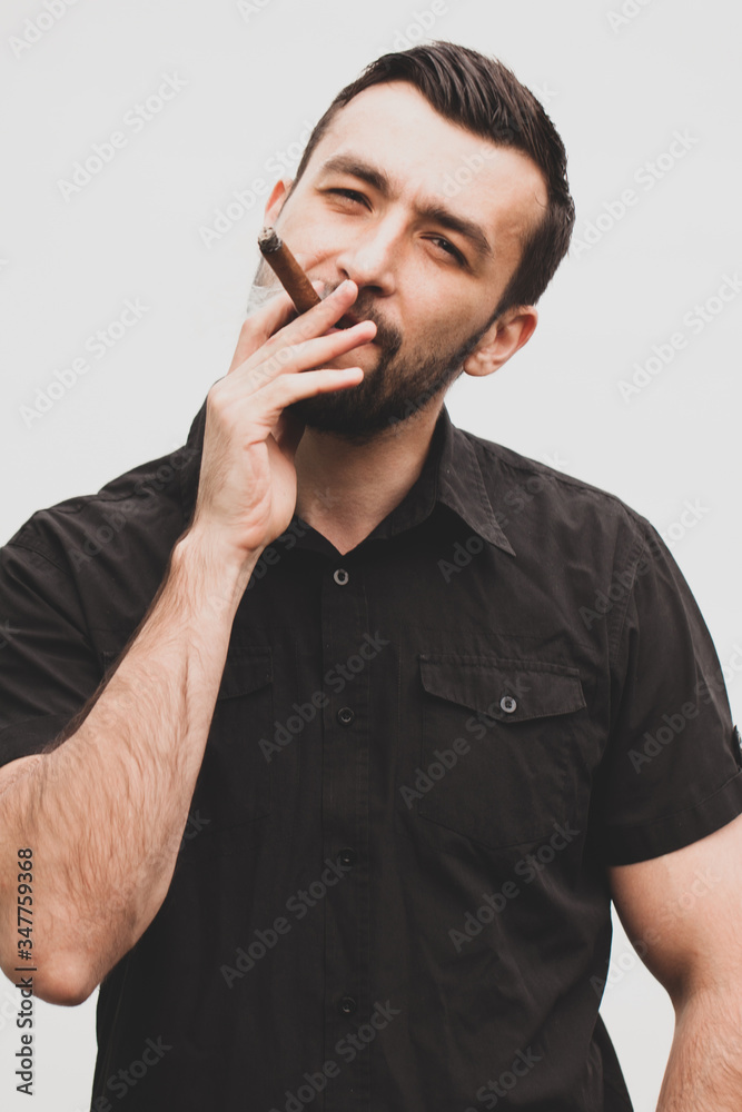 Handsome stylish man smokes a cigar. Handsome stylish man smokes a cigar.