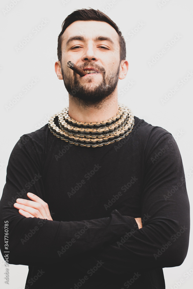 Handsome stylish man smokes a cigar.