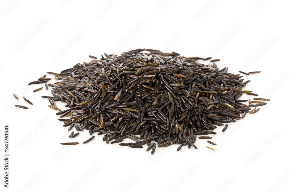 Heap of uncooked, raw, black wild rice grains over white Heap of uncooked, raw, black wild rice grains over white