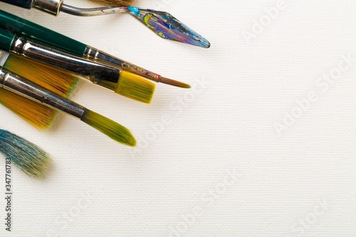 фотографія Artistic art supply utensils with brushes on white canvas background with copy s