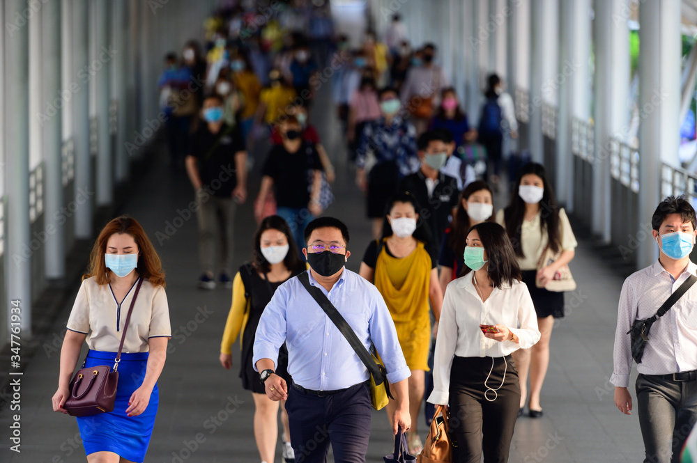 People wearing surgical mask walking in subway station during rush hour People wearing surgical mask walking in subway station during rush hour