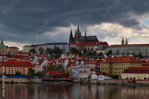Charles Bridge view of Prague castle and its surroundings. Typical view from the Charles Bridge of Castle and colorful buildings with Vltava river on cloudy day.