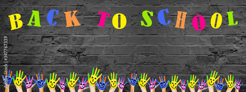 BACK TO SCHOOL banner background panorama -Many brightly painted children's hands with smileys, isolated on rustik brick Stone wall texture, with copy space
