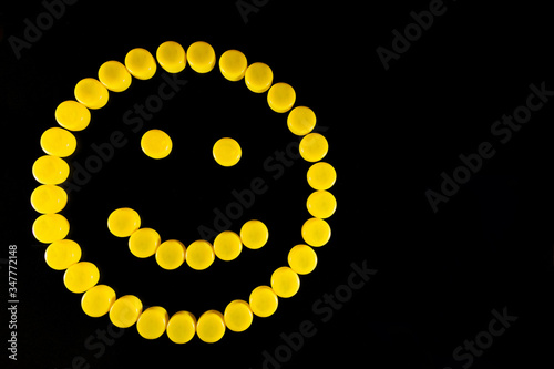 Happy yellow plastic smile on black isolated background