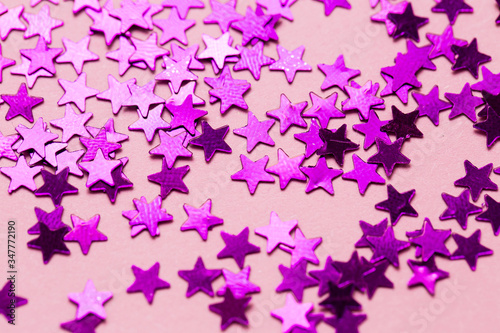 Closeup asterisks sprinkled on a pink isolated background. View from above.